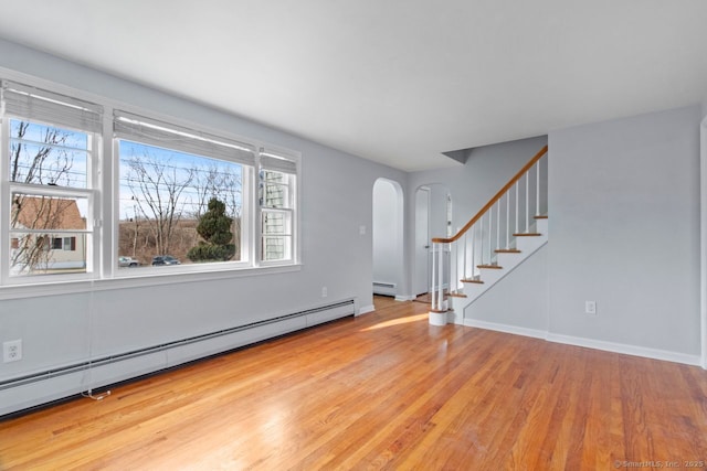 unfurnished living room featuring wood-type flooring and a baseboard radiator