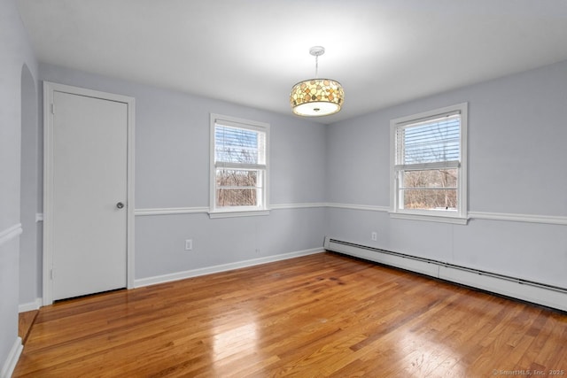 empty room featuring light hardwood / wood-style flooring and a baseboard heating unit