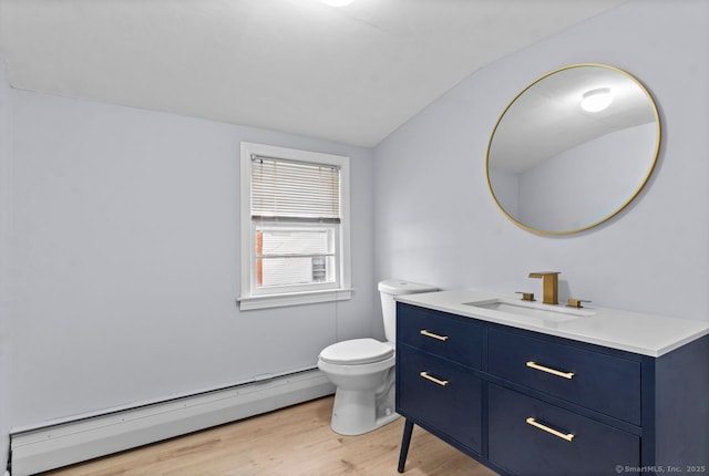 bathroom with vanity, vaulted ceiling, hardwood / wood-style flooring, toilet, and a baseboard radiator