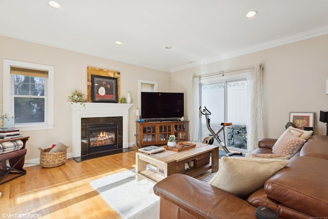 living room with hardwood / wood-style flooring, a high end fireplace, and ornamental molding