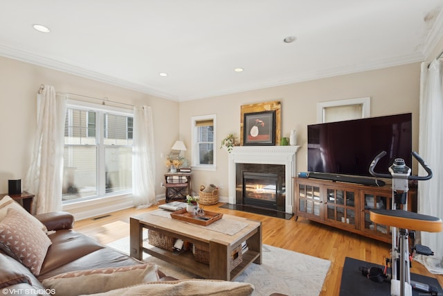 living room with ornamental molding and light hardwood / wood-style floors