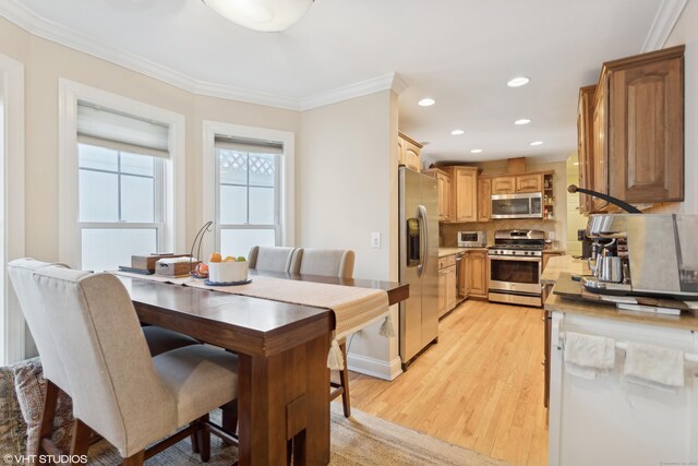 dining area featuring ornamental molding and light hardwood / wood-style floors