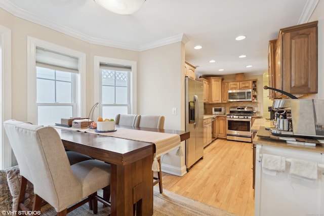 dining space featuring crown molding and light hardwood / wood-style flooring