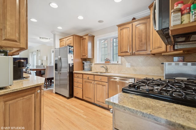 kitchen with sink, backsplash, stainless steel appliances, ornamental molding, and light wood-type flooring