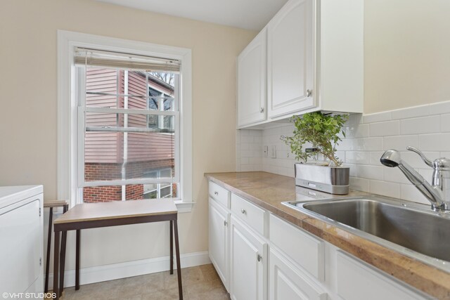 kitchen featuring white cabinetry, sink, light tile patterned floors, and decorative backsplash