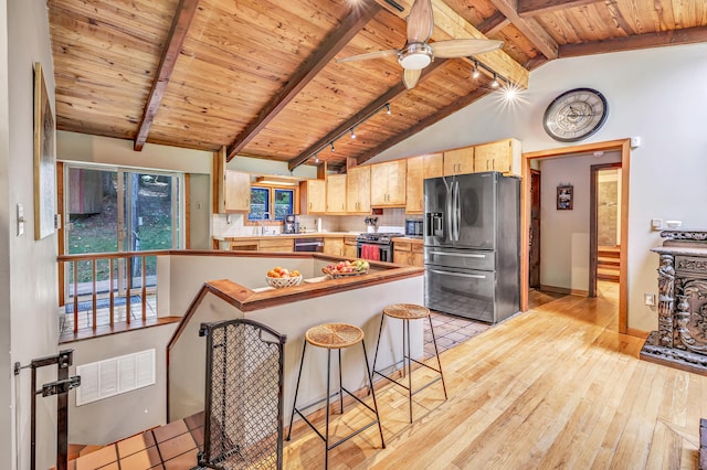 kitchen featuring appliances with stainless steel finishes, lofted ceiling with beams, wooden ceiling, and light brown cabinetry