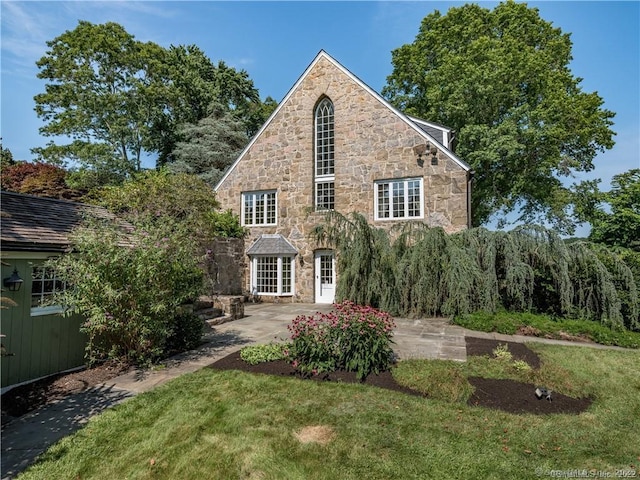 view of front of house with a patio and a front yard