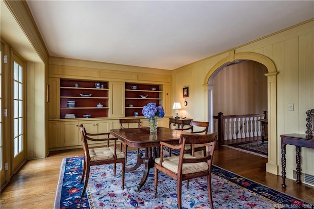 dining space with plenty of natural light, light wood-type flooring, and built in features