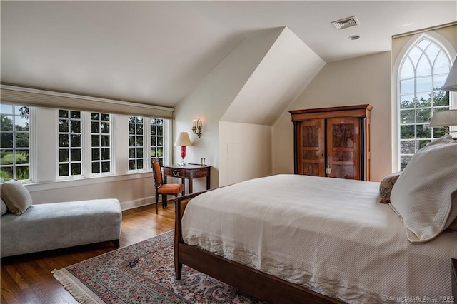 bedroom featuring multiple windows, dark wood-type flooring, and vaulted ceiling