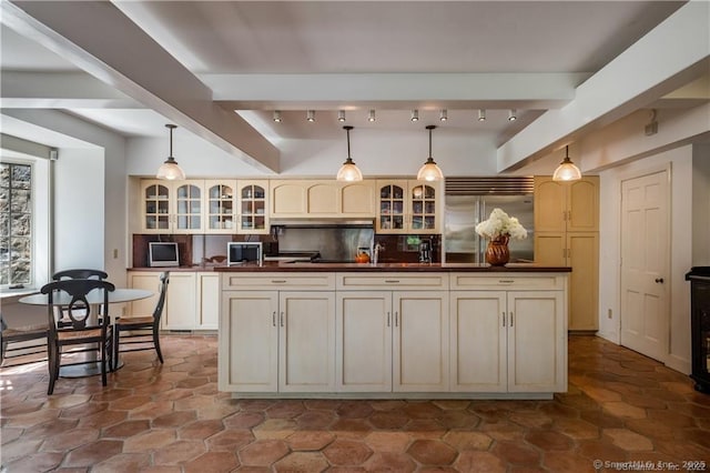 kitchen featuring stainless steel built in refrigerator, cream cabinets, decorative backsplash, and pendant lighting