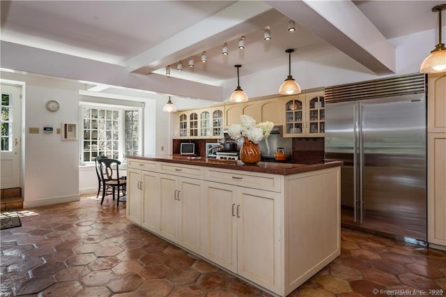 kitchen featuring built in fridge, a wealth of natural light, pendant lighting, and cream cabinetry