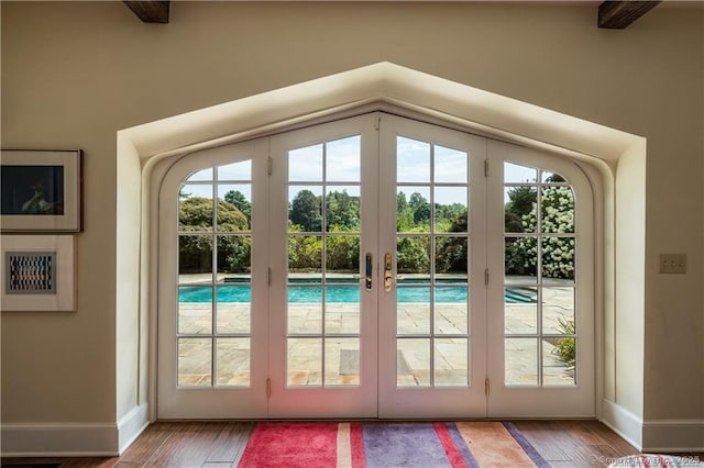 doorway to outside with french doors, beam ceiling, and wood-type flooring