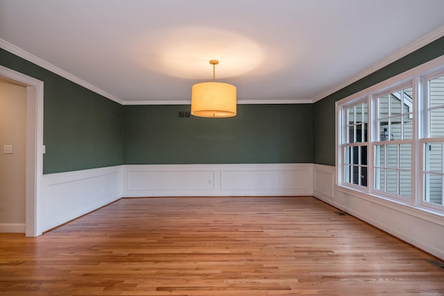 unfurnished dining area featuring crown molding and light hardwood / wood-style flooring