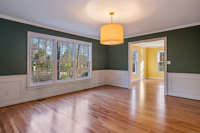 unfurnished dining area with crown molding and light hardwood / wood-style flooring