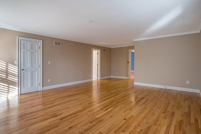 spare room featuring light wood-type flooring and ornamental molding