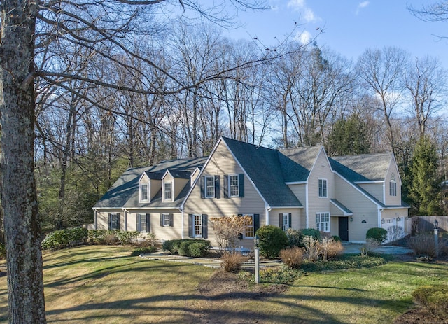 cape cod home with a front lawn and a garage