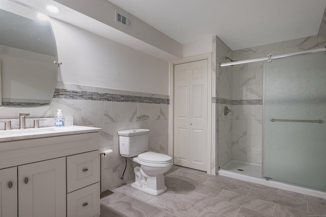 bathroom with tile walls, walk in shower, vanity, and toilet