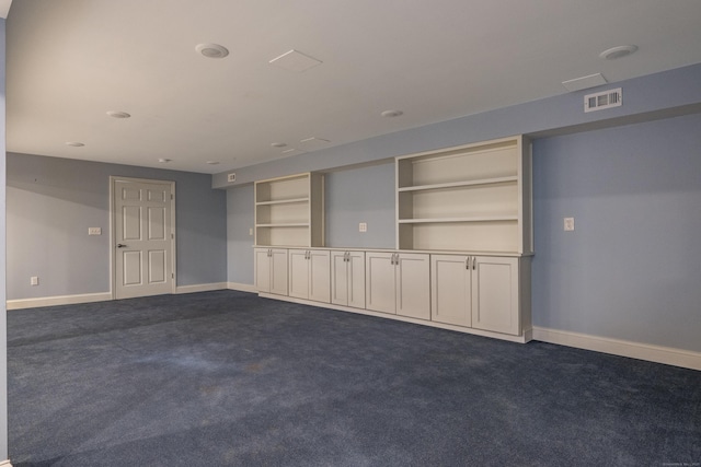 unfurnished living room with dark carpet