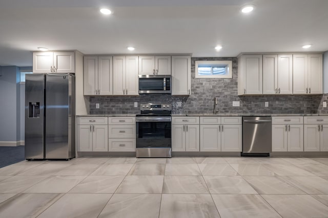 kitchen featuring sink, light tile patterned floors, tasteful backsplash, and appliances with stainless steel finishes