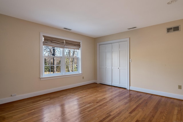 unfurnished bedroom featuring hardwood / wood-style flooring and a closet