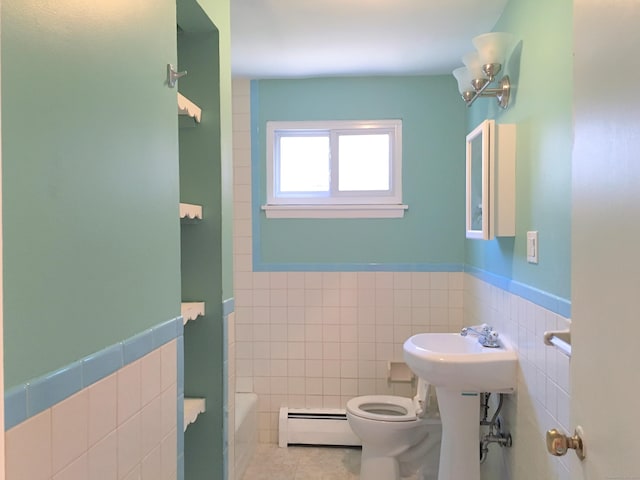 bathroom featuring tile patterned flooring, tile walls, toilet, a washtub, and baseboard heating