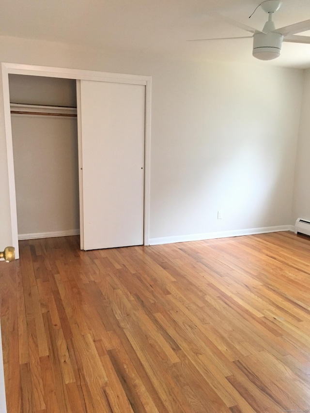 unfurnished bedroom featuring wood-type flooring, a closet, and ceiling fan