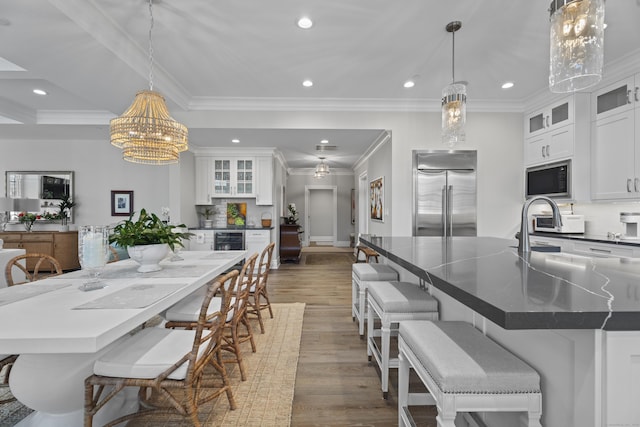 dining area featuring ornamental molding, beverage cooler, dark hardwood / wood-style floors, and an inviting chandelier