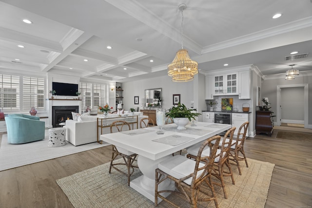 dining area featuring ornamental molding, coffered ceiling, beverage cooler, dark wood-type flooring, and beamed ceiling