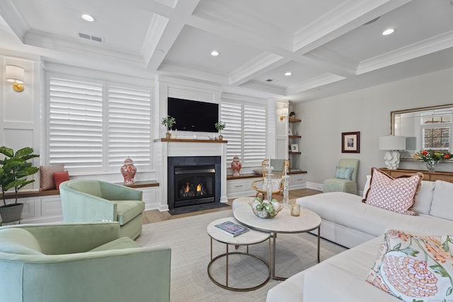 living room featuring beamed ceiling, ornamental molding, coffered ceiling, and light wood-type flooring