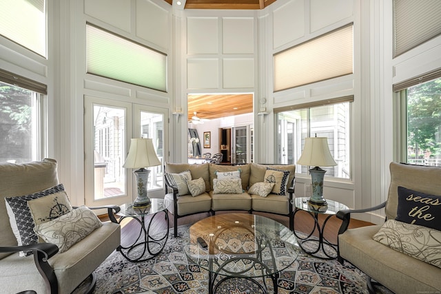 living room featuring ceiling fan, a high ceiling, and a wealth of natural light