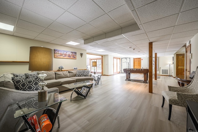 living room with a paneled ceiling and light hardwood / wood-style flooring