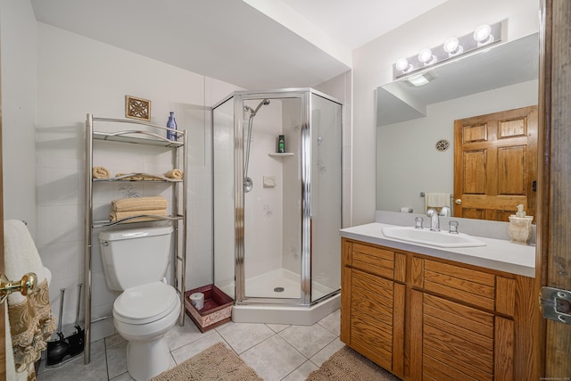 bathroom with tile patterned flooring, vanity, an enclosed shower, and toilet