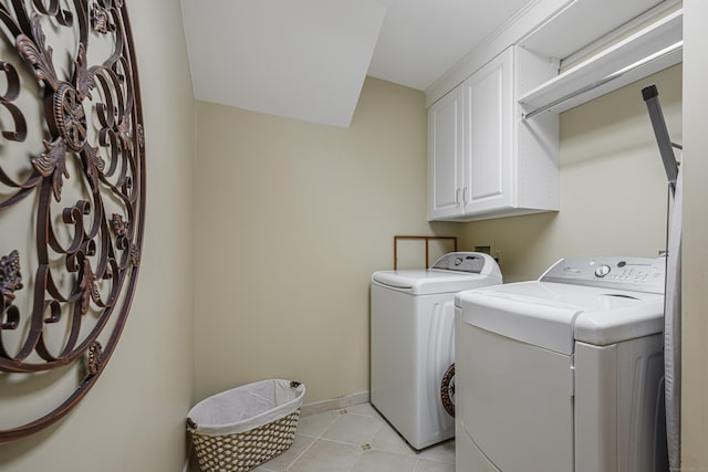 laundry room with washer and dryer, cabinets, and light tile patterned floors