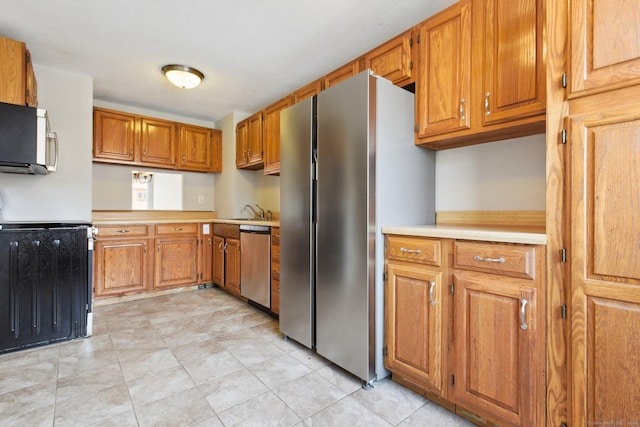 kitchen with light tile patterned flooring, stainless steel appliances, and sink