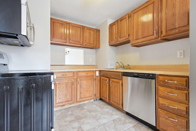 kitchen with stainless steel appliances, sink, and light tile patterned floors