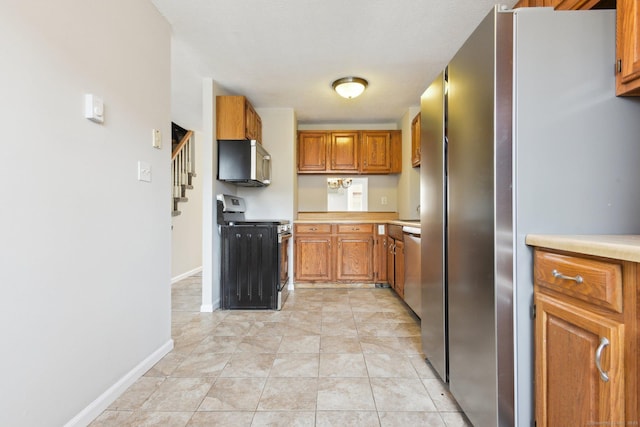 kitchen with light tile patterned floors and stainless steel appliances