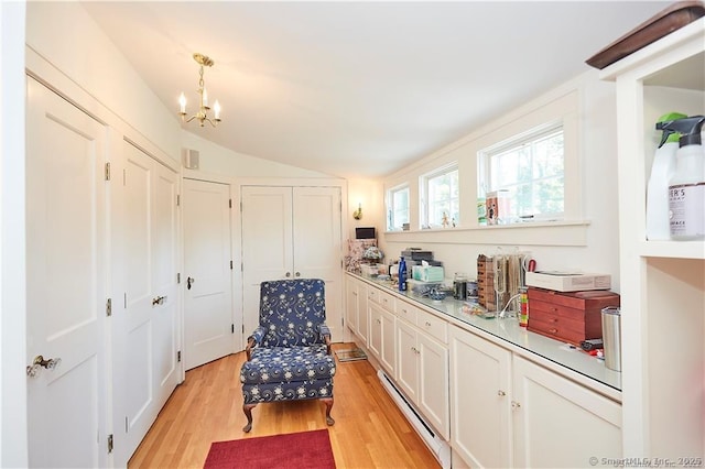 sitting room featuring light hardwood / wood-style flooring, a notable chandelier, and vaulted ceiling