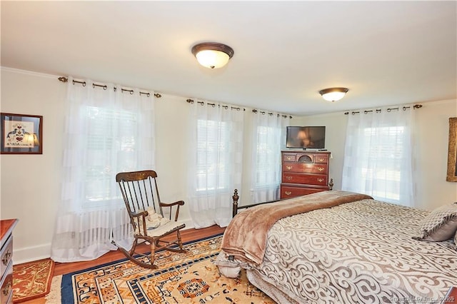 bedroom with ornamental molding and wood-type flooring