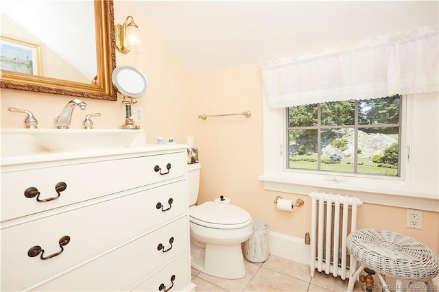 bathroom with toilet, radiator heating unit, vanity, and tile patterned flooring