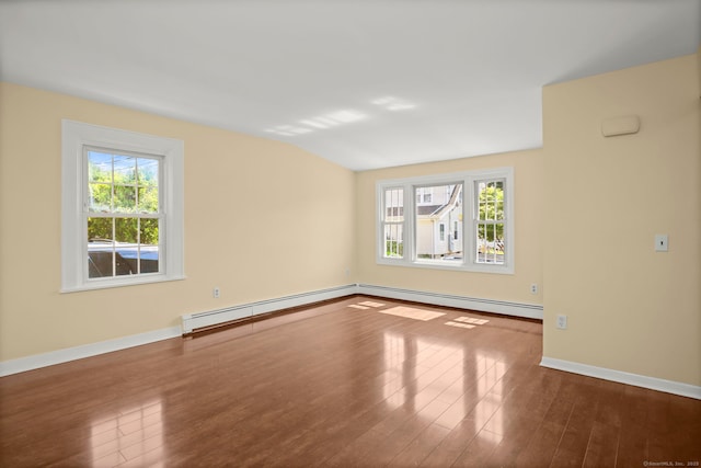 spare room with a wealth of natural light, hardwood / wood-style floors, a baseboard radiator, and lofted ceiling