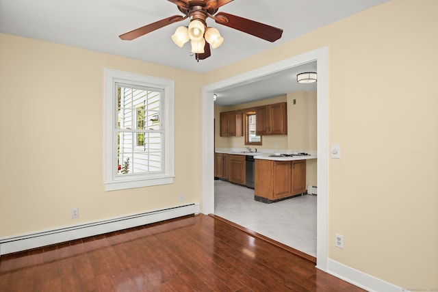 unfurnished living room with ceiling fan, light hardwood / wood-style floors, sink, and baseboard heating