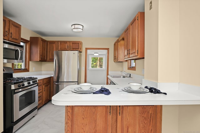 kitchen with kitchen peninsula, sink, and appliances with stainless steel finishes