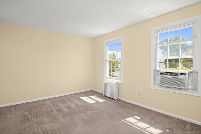 unfurnished room featuring light carpet, radiator heating unit, and cooling unit