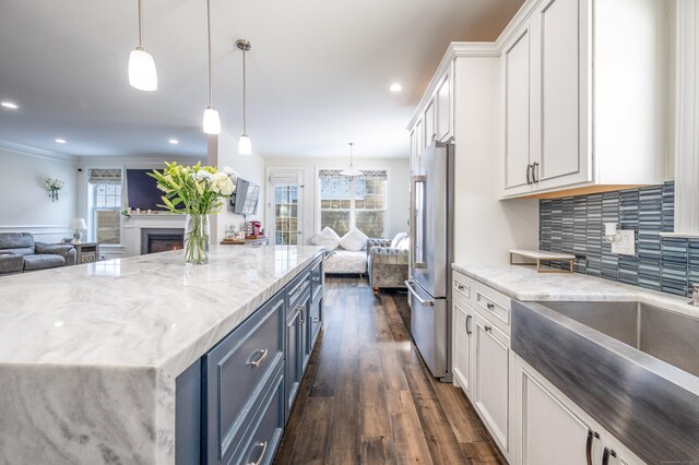 kitchen with blue cabinets, high quality fridge, white cabinets, and decorative light fixtures