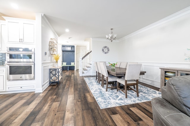 dining space featuring dark wood finished floors, stairway, ornamental molding, wainscoting, and a notable chandelier