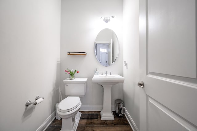 bathroom with wood-type flooring, toilet, and sink