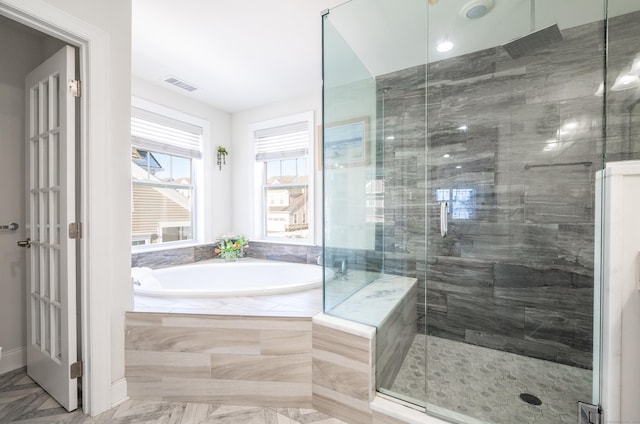 bathroom featuring a bath, visible vents, and a stall shower