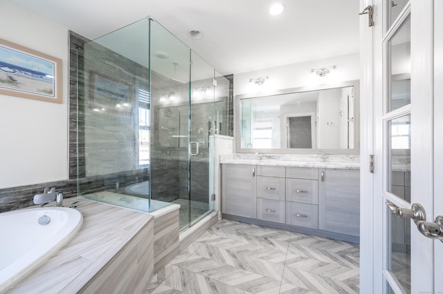 bathroom featuring a garden tub, double vanity, a stall shower, and a sink