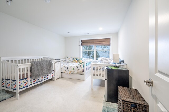 carpeted bedroom featuring stainless steel refrigerator