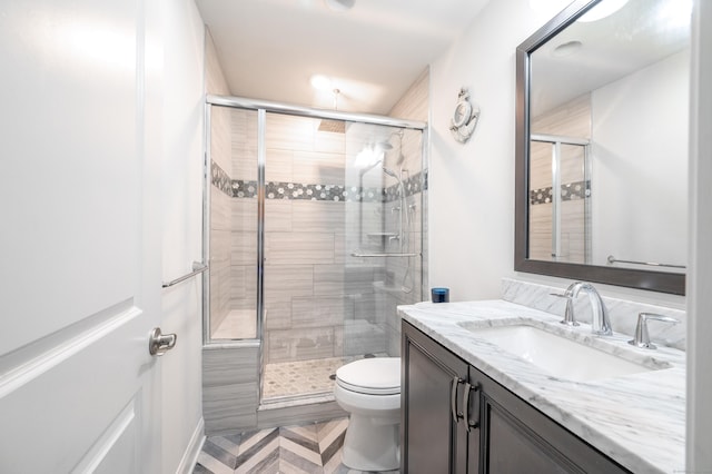 bathroom with vanity, toilet, and a stall shower